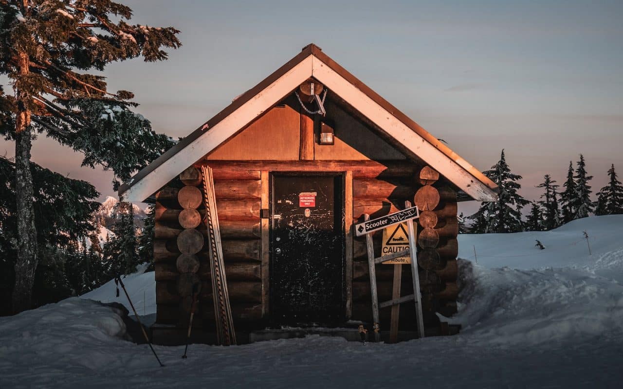 brown wooden house in the middle of icy surface